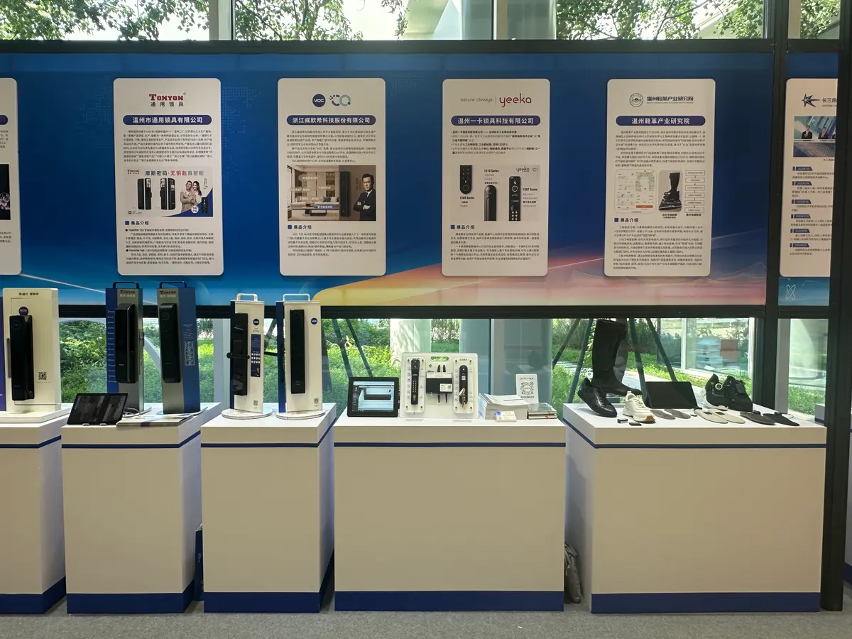 Electronic door locks on display stands, and shoes and insoles with small electronic modules on a plinth to the right